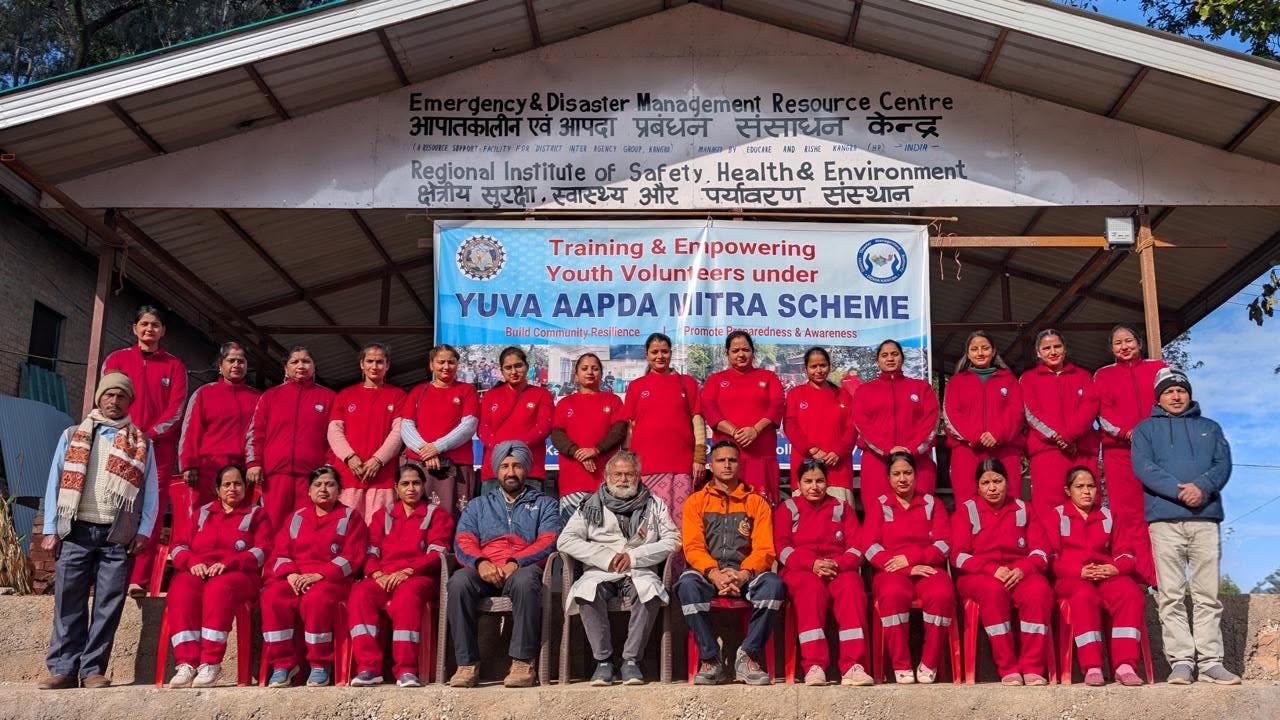 Youth volunteers in red uniforms gathered for a group photo outside the Emergency and Disaster Management Resource Centre in Kangra.