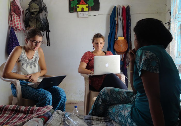 Interns working with laptops in a room.