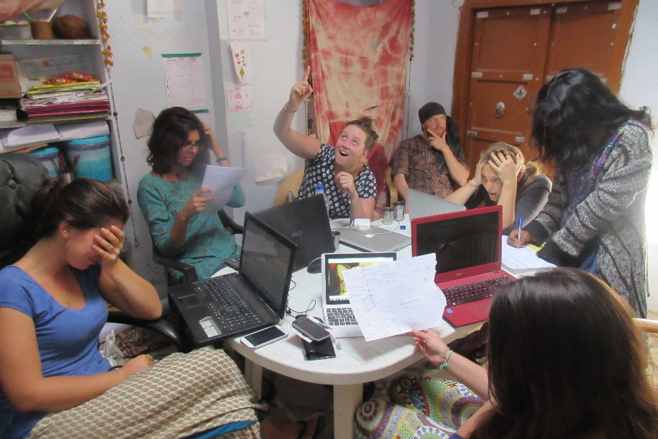 Volunteers sitting around a table during a meeting, with animated expressions on their faces.