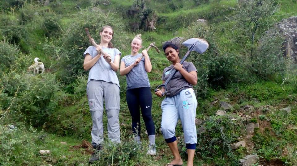 Volunteers posing with tools during project work.