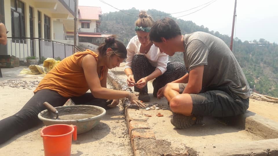 Volunteers working with bricks and cement during a construction project.